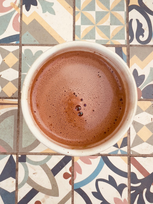 Taza de cacao ceremonial sobre mesa de colores