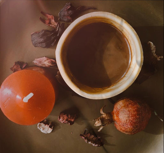 Taza de cacao con vela, granada y objetos de naturaleza