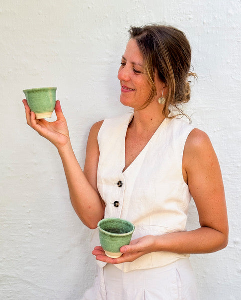 Ceramista Isa Boyd mostrando una taza hecha a mano en su taller