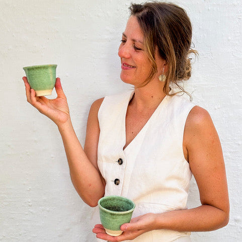 Ceramista Isa Boyd mostrando una taza hecha a mano en su taller