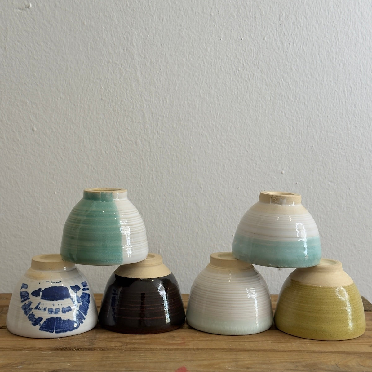 Pirámide de tazas artesanales diferentes colores hechas por Isa Boyd para Sumay Cacao.