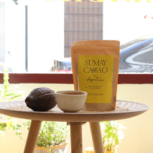 Paquete de Cacao puro con taza y fruto de cacao sobre mesa de madera