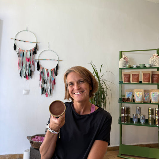 Agostina de Sumay Cacao mostrando mousse de cacao ceremonial en taza artesanal de Isa Boyd, interior de la tienda en Ronda