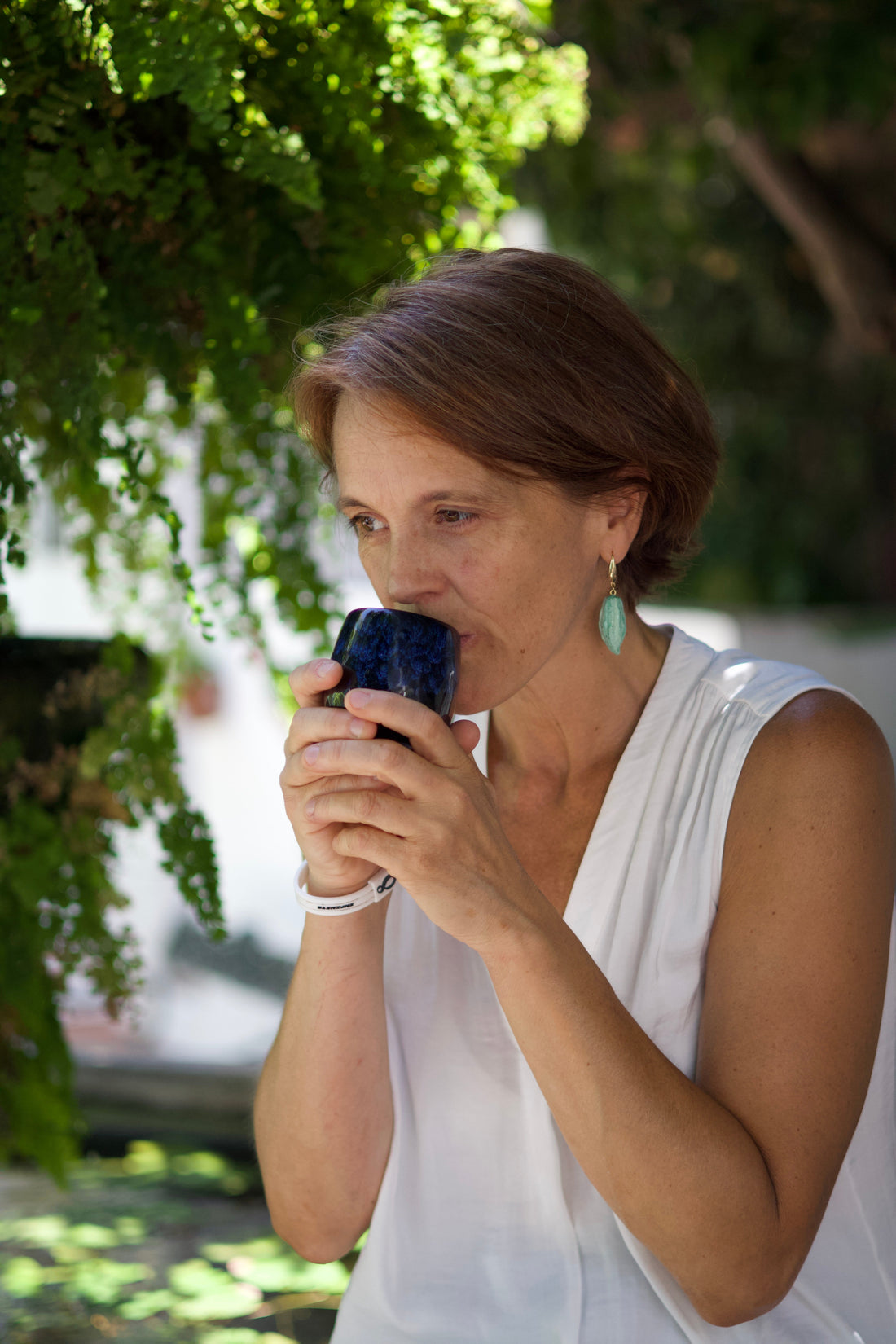 Mujer bebiendo cacao con fondo de naturaleza