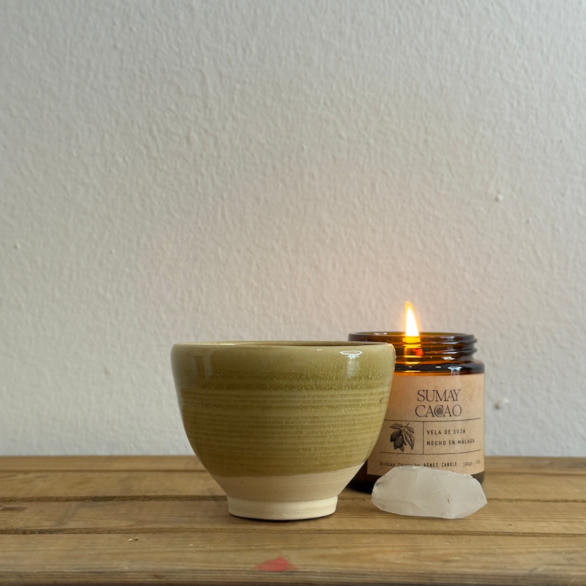 Taza de 110 ml con vela encendida y cuarzo sobre mesa madera y fondo blanco.