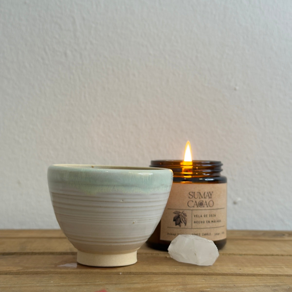 Taza de Isa Boyd diseñada exclusivamente para Sumay Cacao, junto a vela y cuarzo.