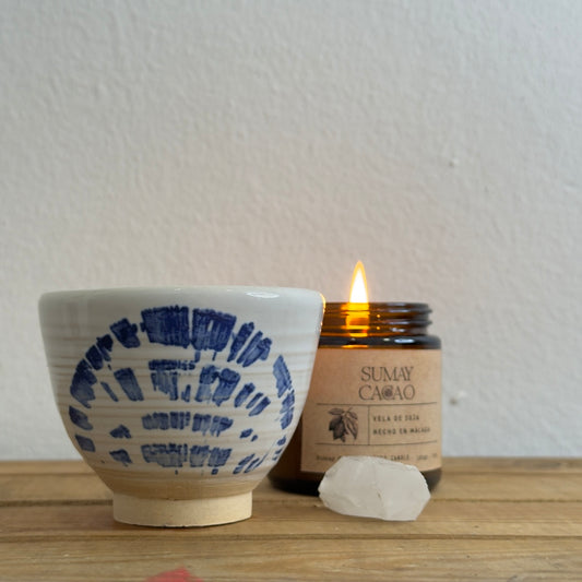 Taza de cerámica artesanal "abanico" con cuarzo y vela encendida.