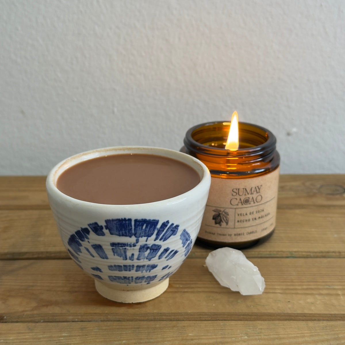 Taza ceremonial con cacao, vela y cuarzo.