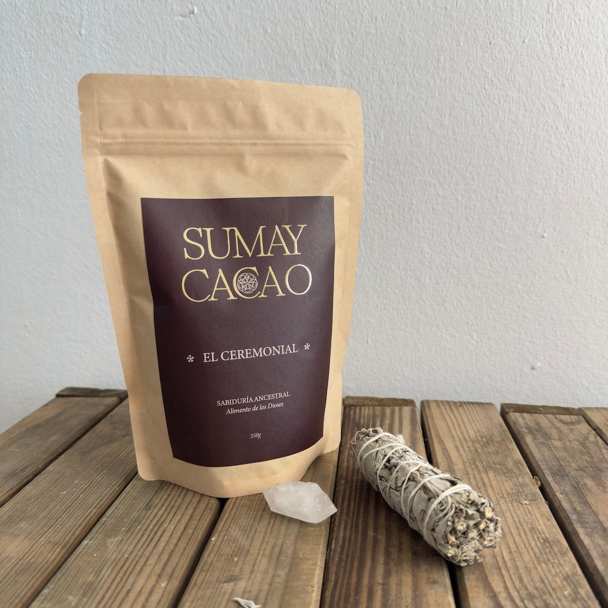 Paquete de acao ceremonial, un cuaro y atado de salvia sobre mesa de madera.