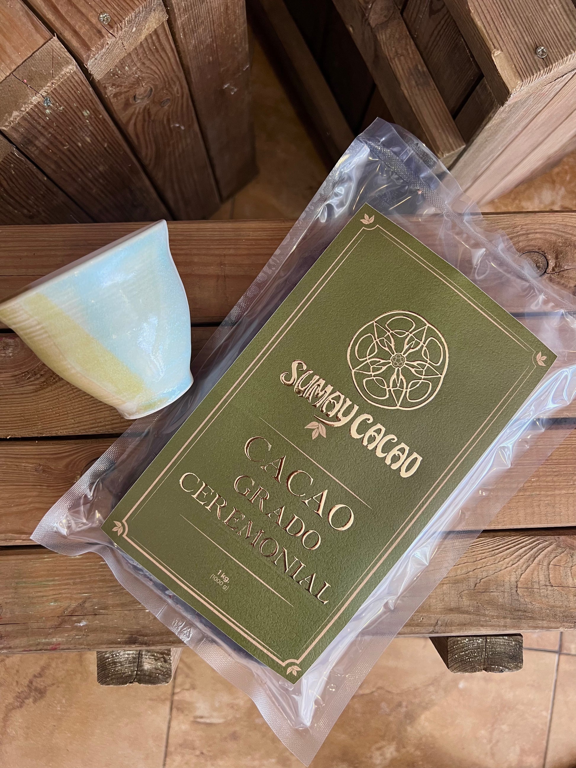 kilo Cacao Ceremonial Sumay con taza artesanal sobre cajon de madera