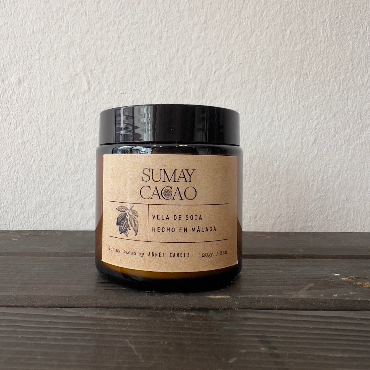Vela de soja Sumay Cacao, en frasco marrón con tapa, sobre cajón de madera y fondo blanco.