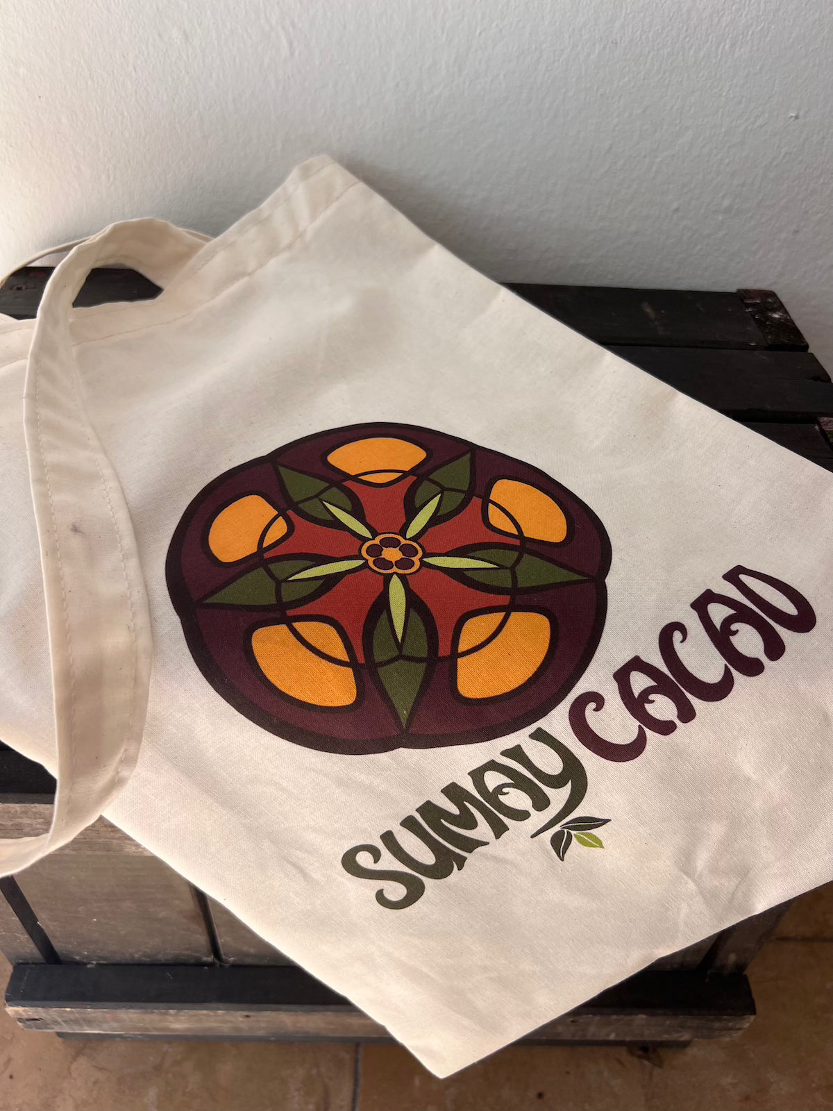 Tote bag sobre cajón de madera y fondo blanco.