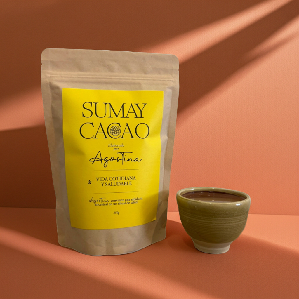 Bolsa de pasta de cacao ceremonial Sumay Cacao Vida Cotidiana 350 g junto a una taza de cacao caliente sobre fondo melocotón, iluminación cálida y sombras naturales.