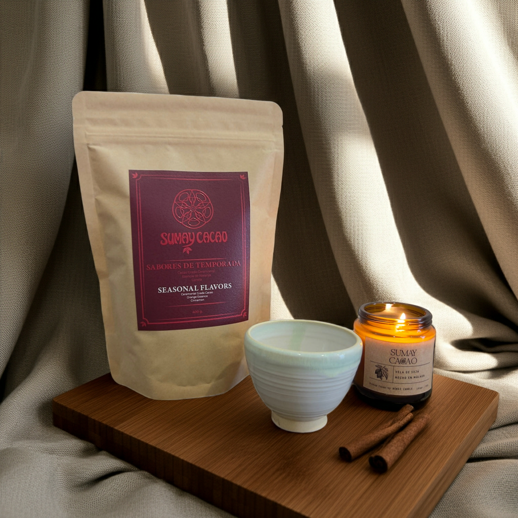 Pack Calidez del Hogar de Sumay Cacao con cacao ceremonial de naranja y canela, taza artesanal y vela sobre mesa de madera con luz cálida