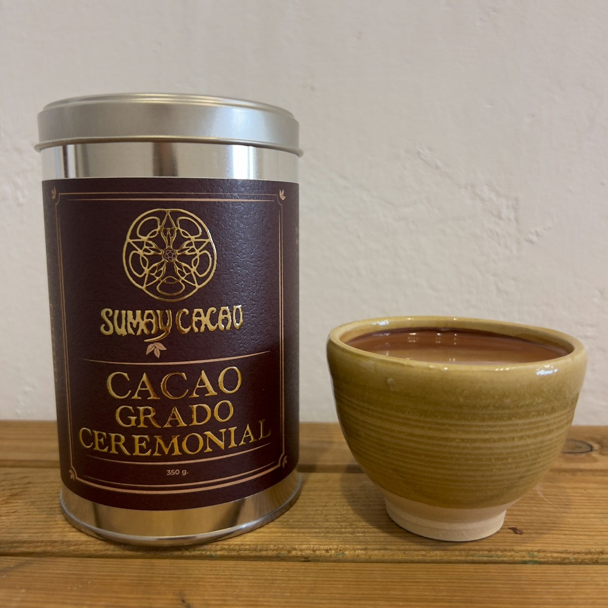 Lata de cacao ceremonial con taza de cerámica artesanal y cacao.