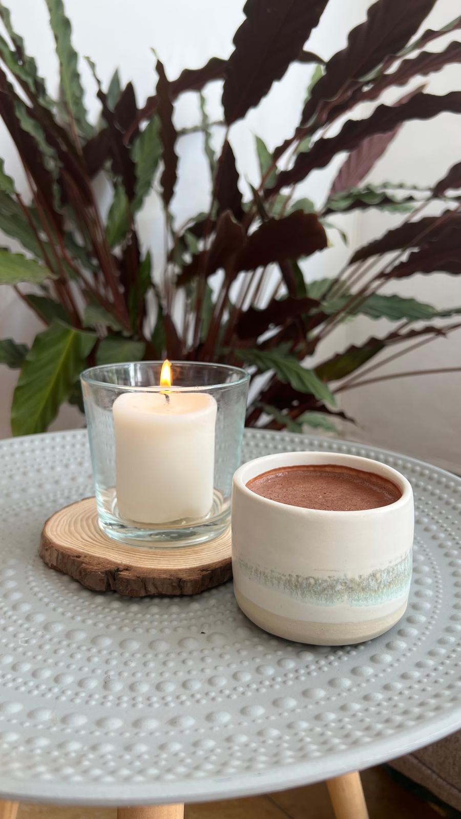 taza de cacao ceremonial con vela en espacio tranquilo y luz natural, ritual diario Sumay Cacao