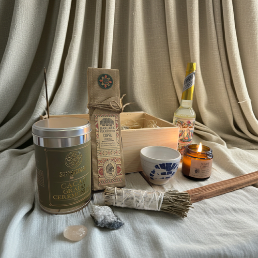 Caja Ritual Ceremonial de Sumay Cacao con cacao ceremonial, vela, salvia, cuarzo, copal y taza artesanal, presentada en un ambiente navideño acogedor con luces cálidas y decoración natural.