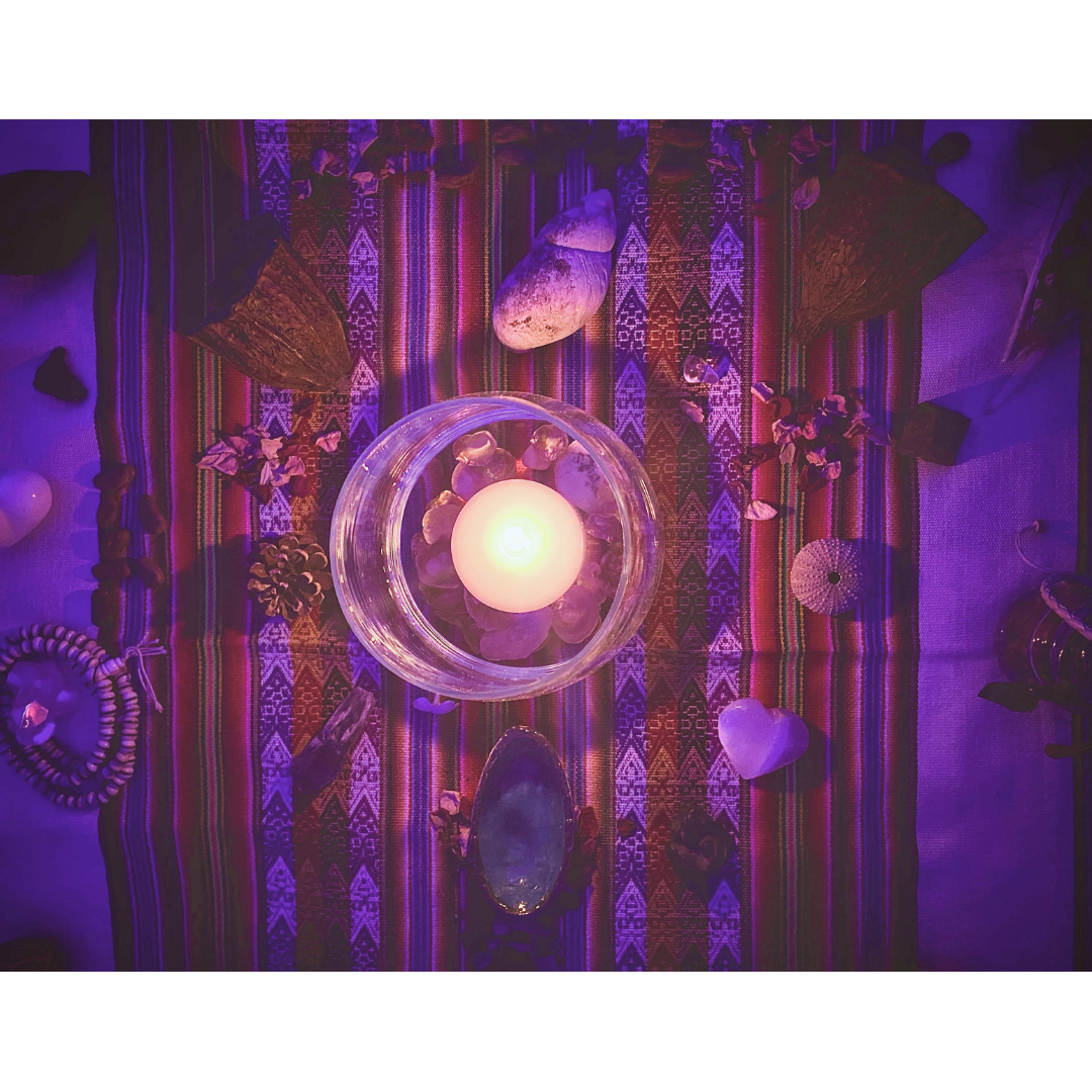 Altar de ceremonia de cacao con vela en el centro y elementos de la naturaleza alrededor honrando al cacao y la vida